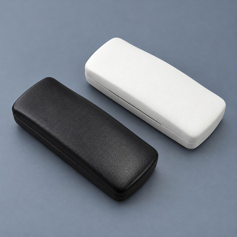 Black and white covered metal eyeglass cases with matching rounded rectangular clamshell shapes.