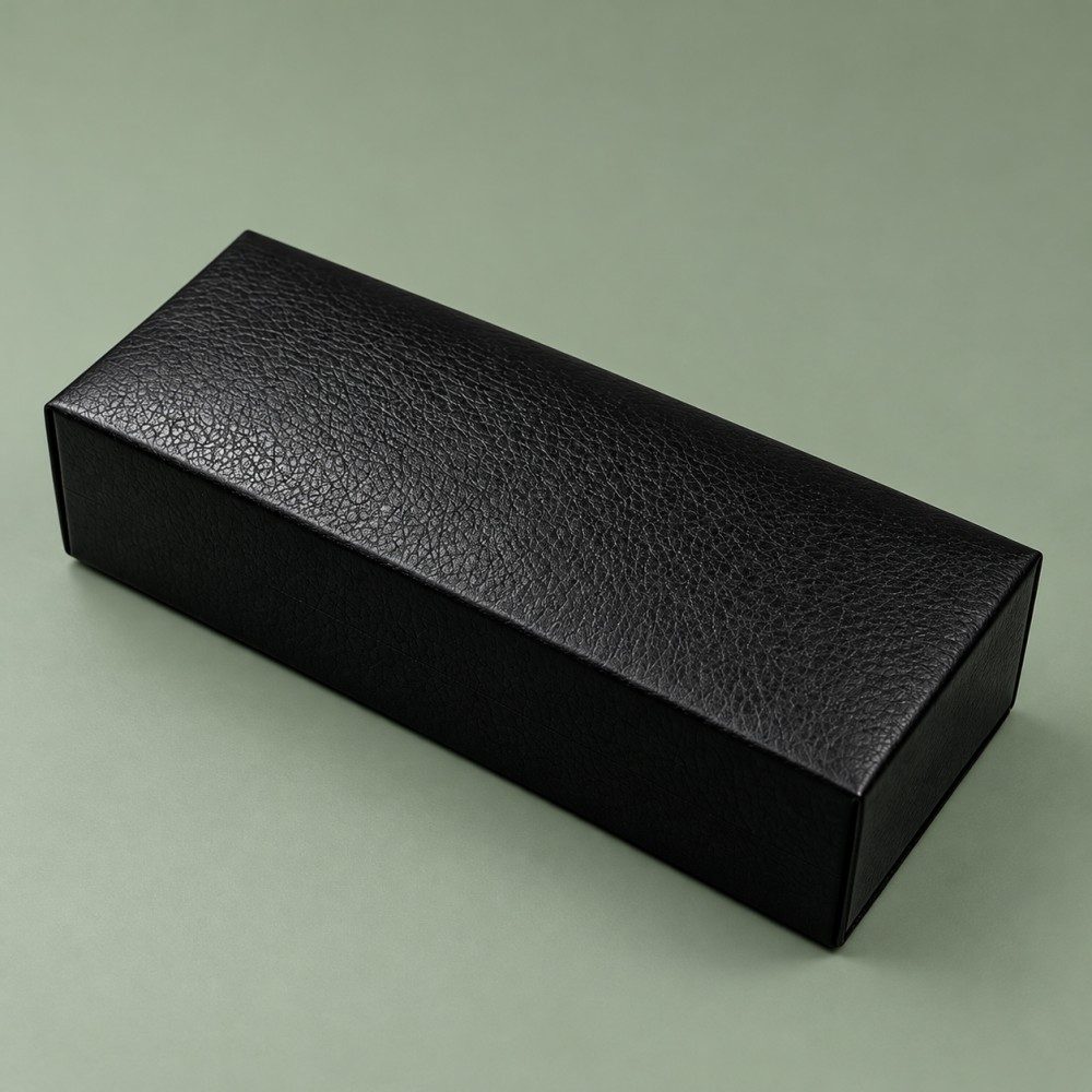 Closed black foldable sunglasses case with a textured exterior and rectangular shape on a muted green background.