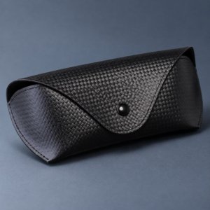 Open black eyewear pouch showing soft lining, press-stud closure and sunglasses