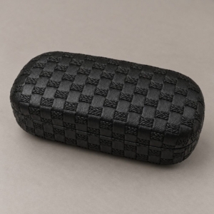 Black hard shell glasses case with a basket-weave-effect texture and rounded corners on a warm gray background.