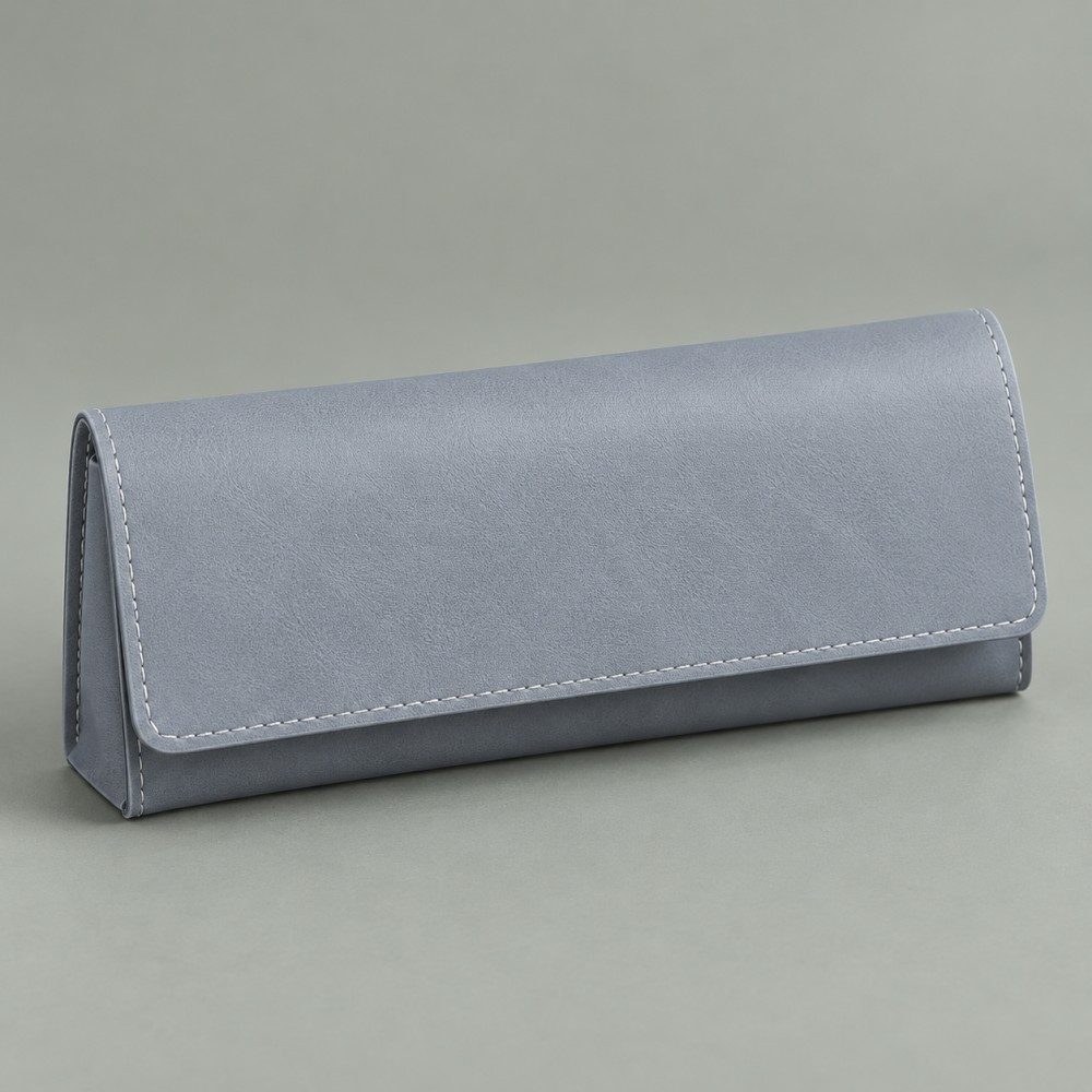 Blue-gray soft eyeglass case with a broad rectangular flap and light edge stitching on a muted sage-gray background.