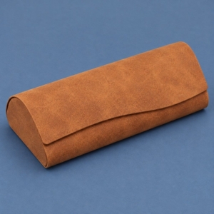 Brown textured PU glasses case with a curved wrapover flap on a slate blue background.