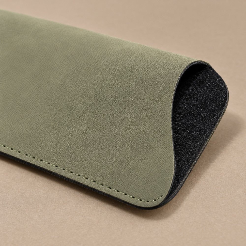 Detail of matching stitching and rounded corners on a dark green PVC eyewear sleeve