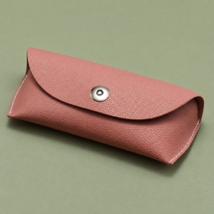 Pink soft glasses case with a rounded flap and central silver-tone fastener