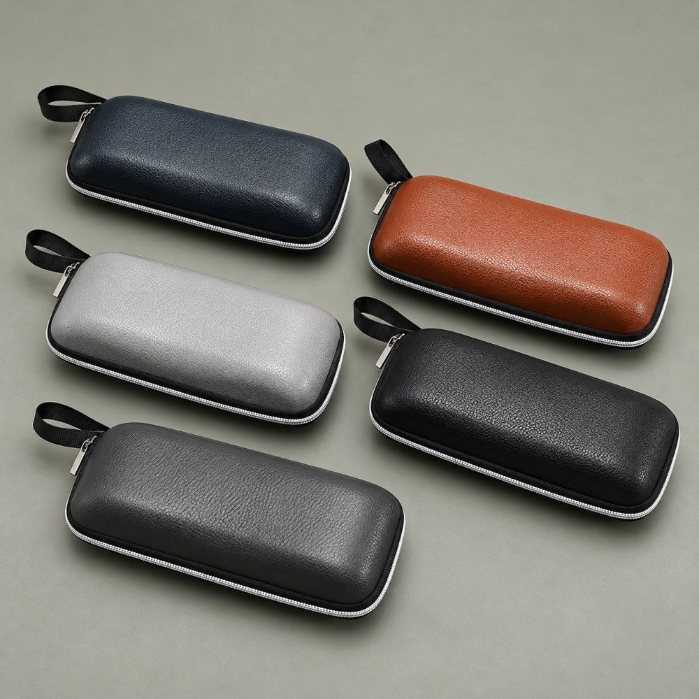 Matching zipper glasses cases in navy, brown, light grey, black and dark grey, each with a contrasting zipper and black carry loop.