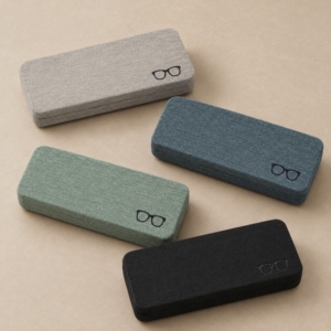 Four textured glasses cases in gray, gray-blue, pale green and black with matching rectangular shapes.