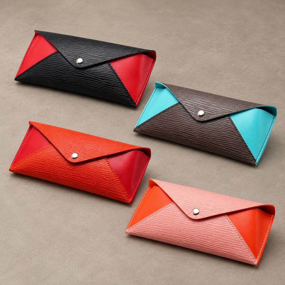 Four envelope glasses cases in black/red, brown/turquoise, brick red/red and pink/orange color combinations.