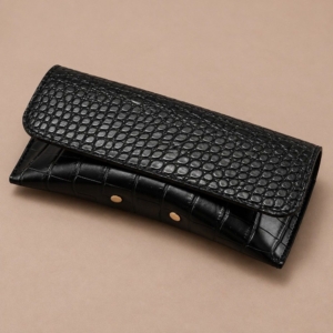 Black crocodile-effect snap closure glasses case with stitched flap and gold-tone details
