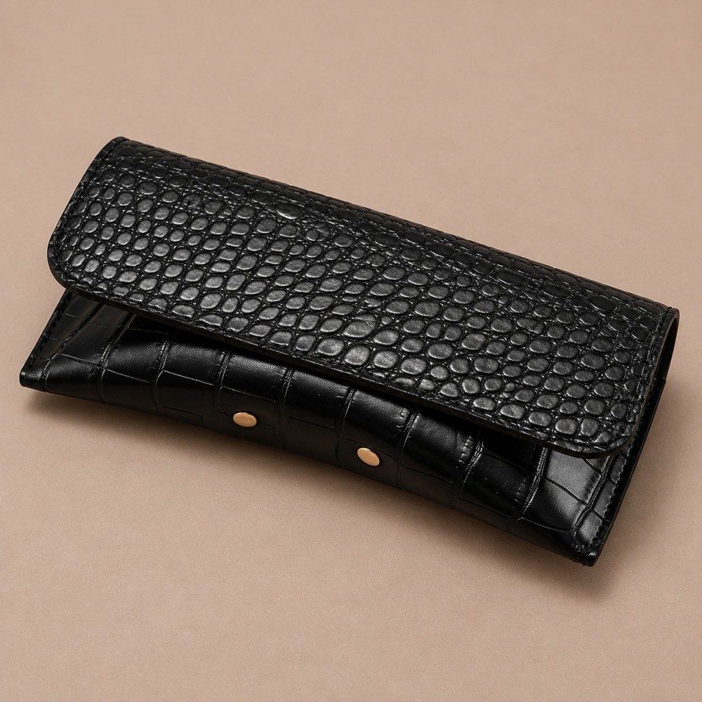 Black crocodile-effect snap closure glasses case with stitched flap and gold-tone details