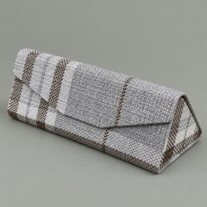 Gray woven plaid foldable sunglasses case with a triangular end panel and broad overlapping flap on a sage-gray background.