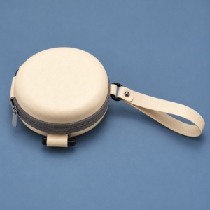 Ivory round EVA zippered sunglasses case with a gray zipper and matching wrist strap on a blue background