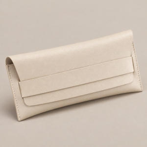 Ivory PVC faux leather eyeglass case with a tuck-in flap, wide horizontal retaining band and stitched side seams.