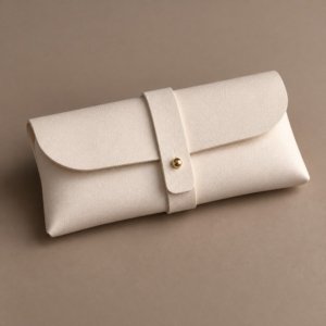 Ivory envelope-style glasses pouch with a central strap and gold-tone stud