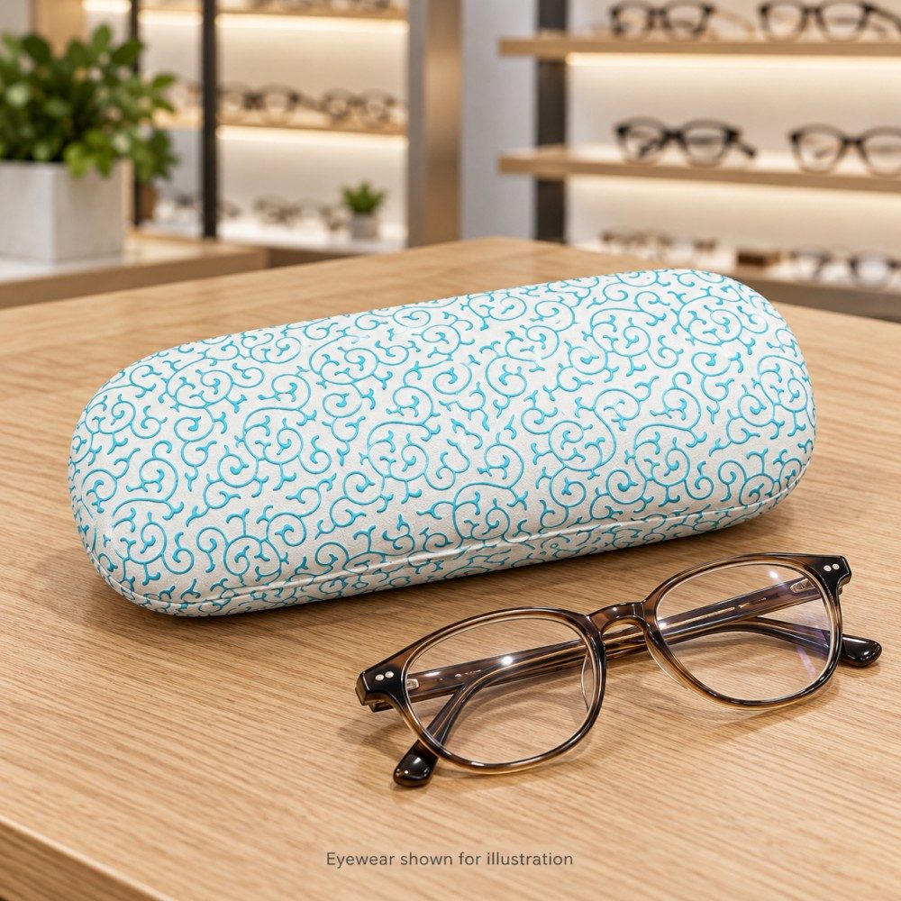 Ivory and blue scroll-pattern eyeglass case beside folded glasses on a wooden optical-store counter.