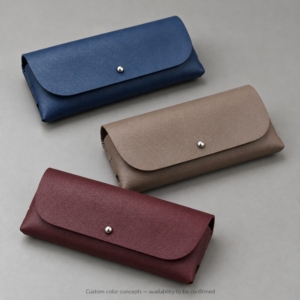 Soft eyeglass cases in navy blue with taupe and burgundy custom color concepts, labeled as subject to availability confirmation.