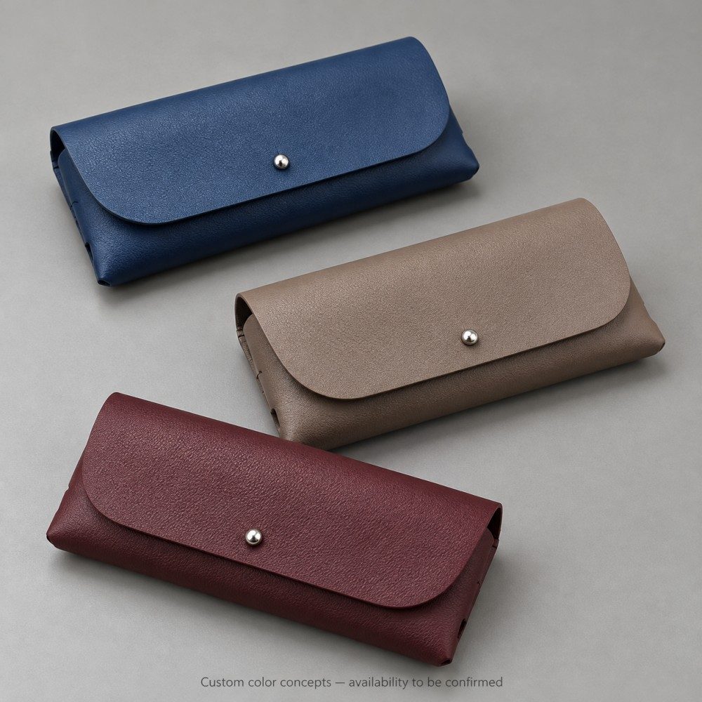 Soft eyeglass cases in navy blue with taupe and burgundy custom color concepts, labeled as subject to availability confirmation.