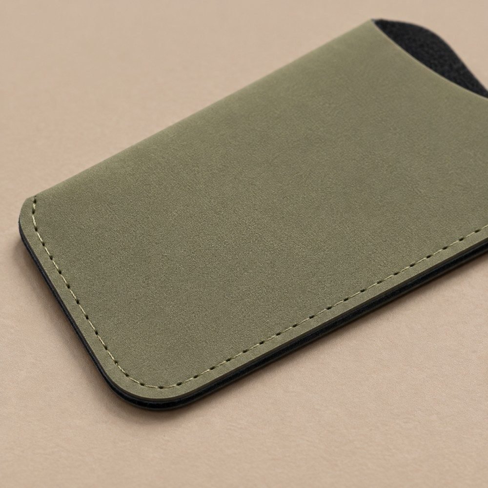 Dark green slip-in glasses sleeve with black eyeglasses partially inserted
