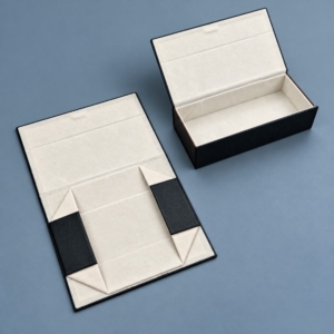 Folding sunglasses case shown open and flattened, revealing light-colored lining, inward-folding end panels and triangular corner folds.
