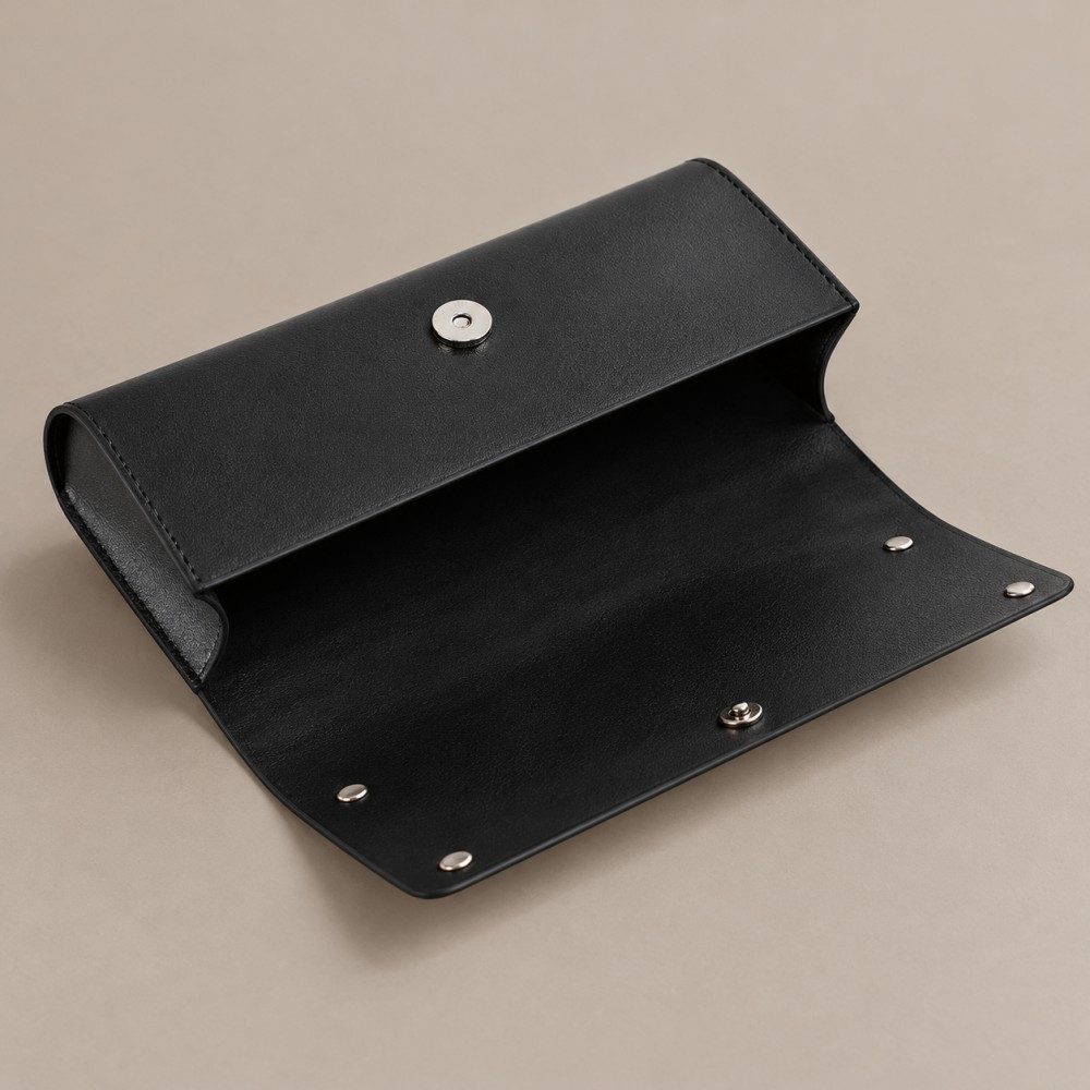 Open black glasses case showing the dark interior, magnetic closure fittings and mirror fasteners on the inside of the flap.