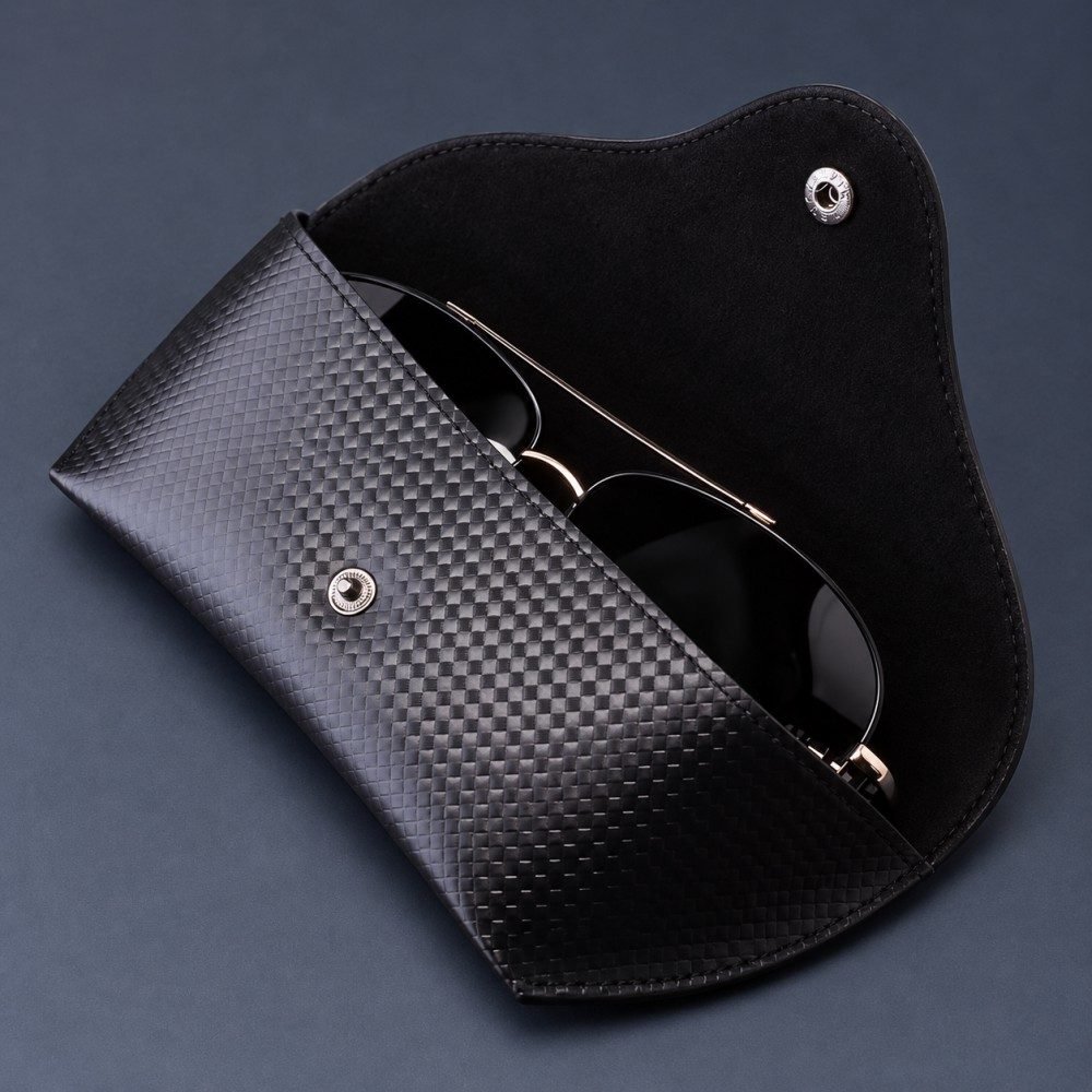 Black snap-closure eyewear pouch displayed beside sunglasses on an optical counter
