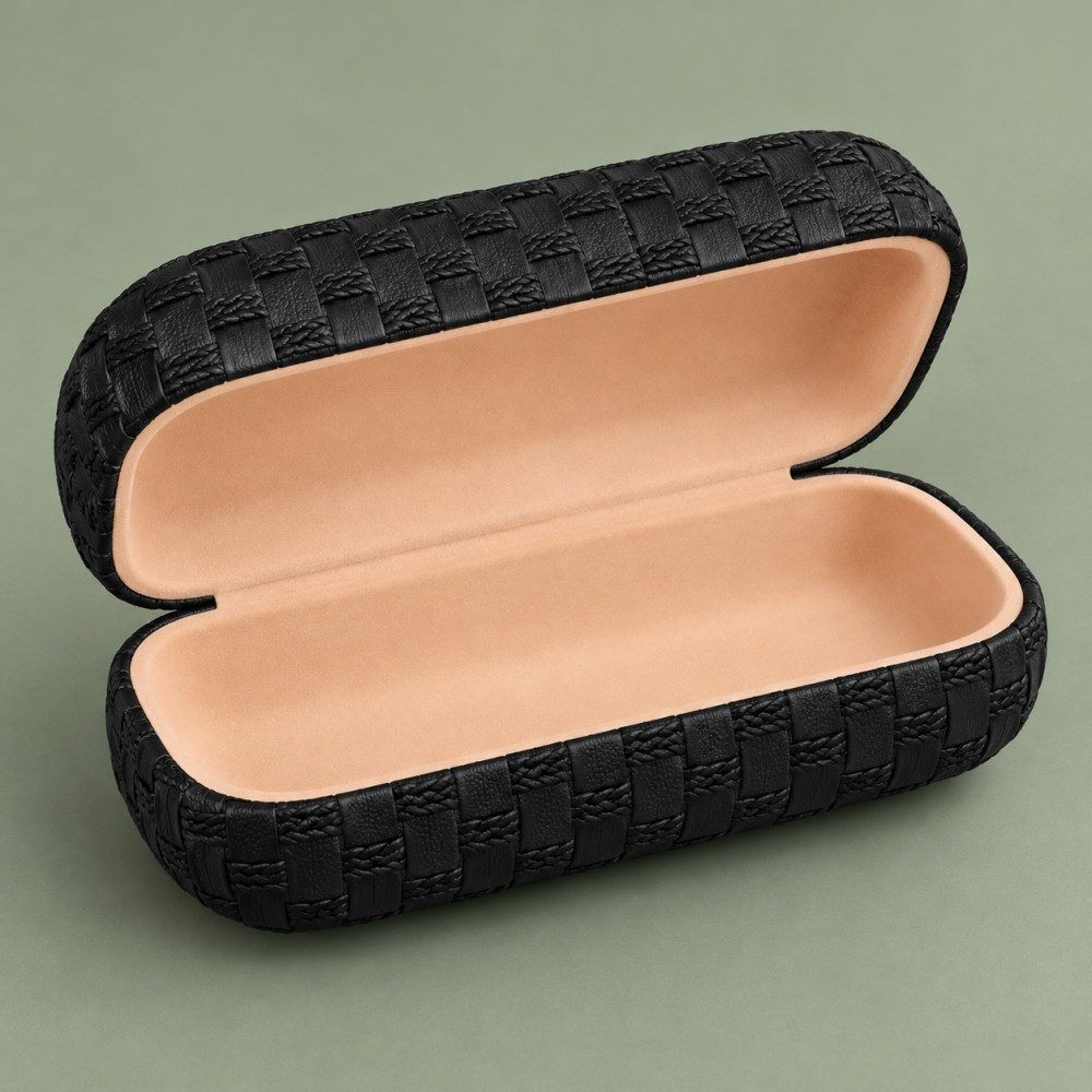 Open black textured glasses case showing a light peach lining inside both halves of the hinged clamshell.