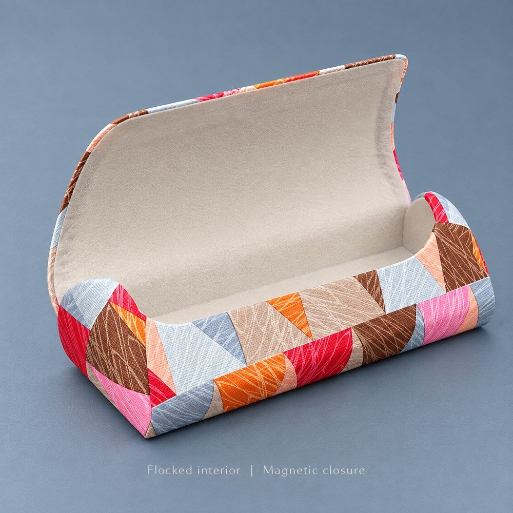Open brown, red and pink patterned magnetic glasses case showing ivory flocked lining and a broad raised flap.