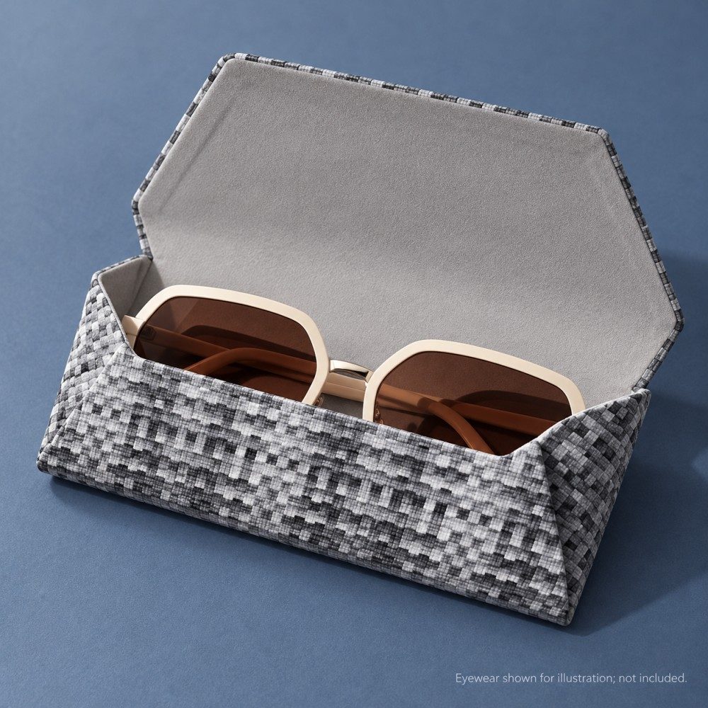 Open gray patterned glasses case showing light gray flocked lining and a pair of cream-framed sunglasses.