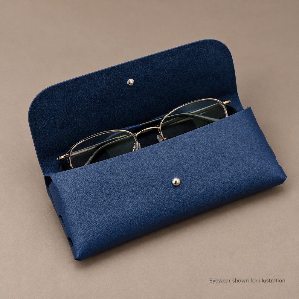 Open navy soft eyeglass case showing its suede-like interior and a pair of folded metal-frame glasses for illustration.