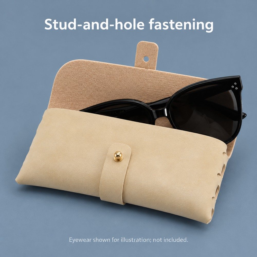 Open pale yellow eyeglass case holding black cat-eye sunglasses, showing the released strap hole and gold-tone ball-head stud.
