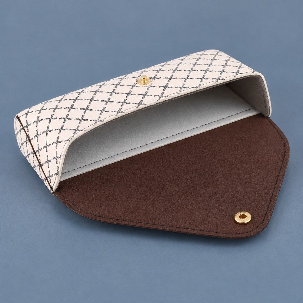 Open white patterned sunglasses case showing its gray lining, brown inner flap and two-part gold-tone press snap.