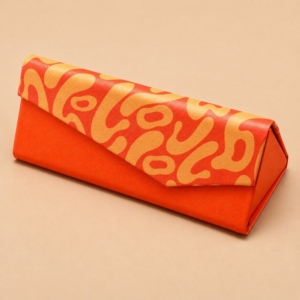 Orange custom handmade glasses case with a patterned envelope flap and triangular shape