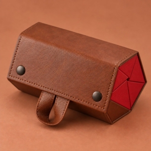 Brown glasses case with stitched flap edges, dark snap fasteners and red folded panels