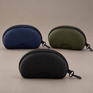 Matching EVA sunglasses cases in black with illustrative navy and olive color concepts, each with a black zipper and side clip.