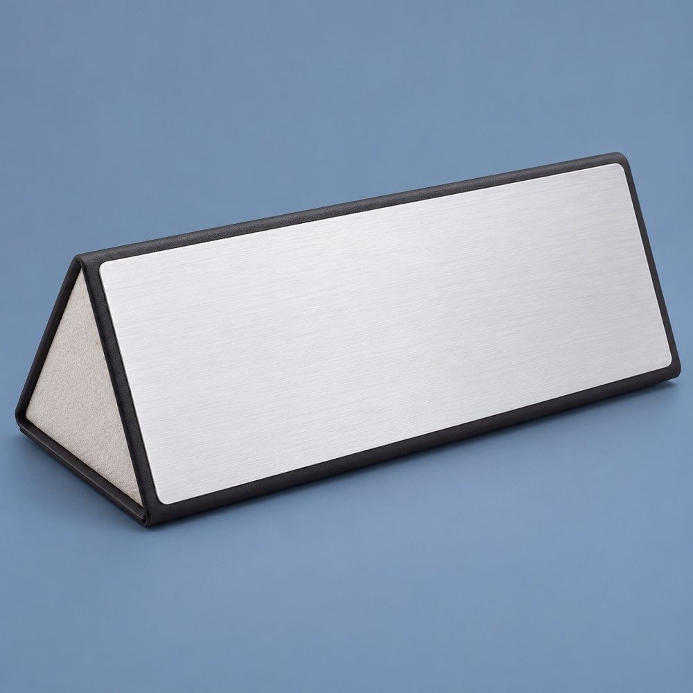 Triangular magnetic eyeglass case with a brushed silver-effect panel, black trim and a pale textured end.