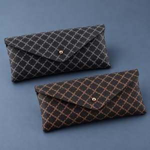 Two YX1106 soft eyeglass cases showing grey-white and brown diamond lattice patterns on black with matching gold-tone snaps.