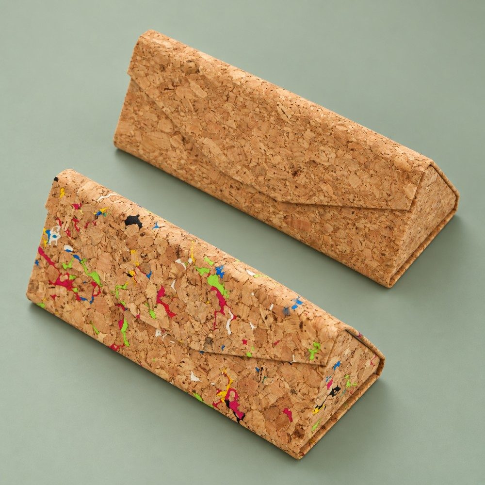 Two triangular folding glasses cases showing plain tan and multicolor-fleck cork-textured finishes.