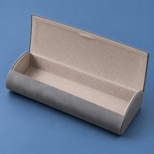 Open gray JH eyeglass case showing the light gray flocked interior, lined flap and curved front wall.