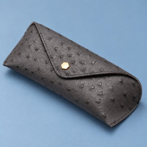 Grey custom soft glasses case with ostrich-effect texture and a gold-tone hexagonal snap